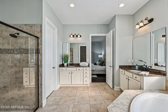 a bathroom with a granite countertop sink and a bathtub