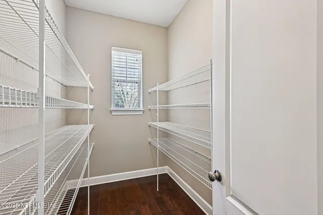 a view of a hallway with wooden floor and windows