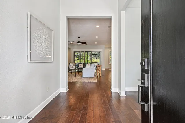 a living room with furniture a potted plant and wooden floor