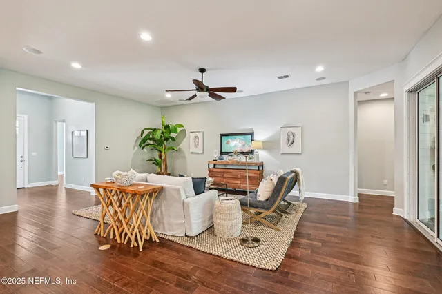 a living room with furniture kitchen view and a chandelier