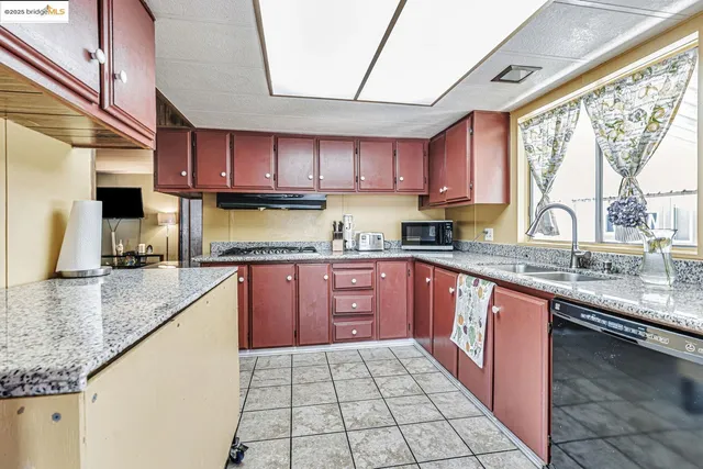 a large kitchen with stainless steel appliances granite countertop a stove sink and cabinets