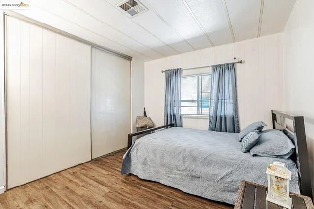 a bedroom with a bed and wooden floor