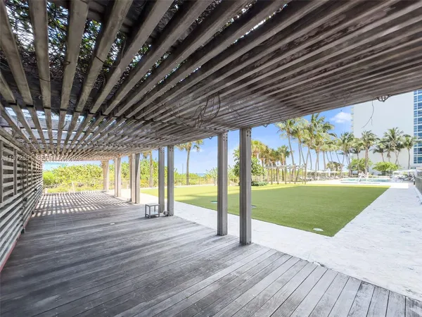 a view of a patio with a table and chairs under an umbrella