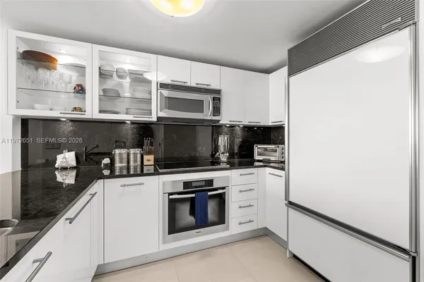 a kitchen with stainless steel appliances a stove and white cabinets