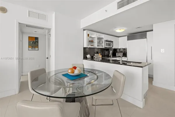 a kitchen with stainless steel appliances kitchen island granite countertop a table and chairs