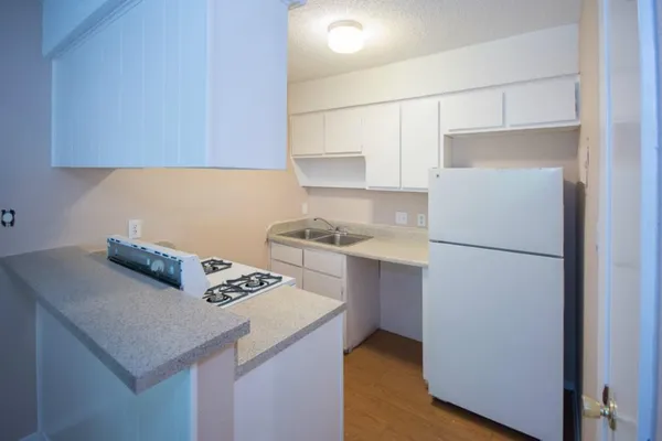 a kitchen with a refrigerator and a stove top oven