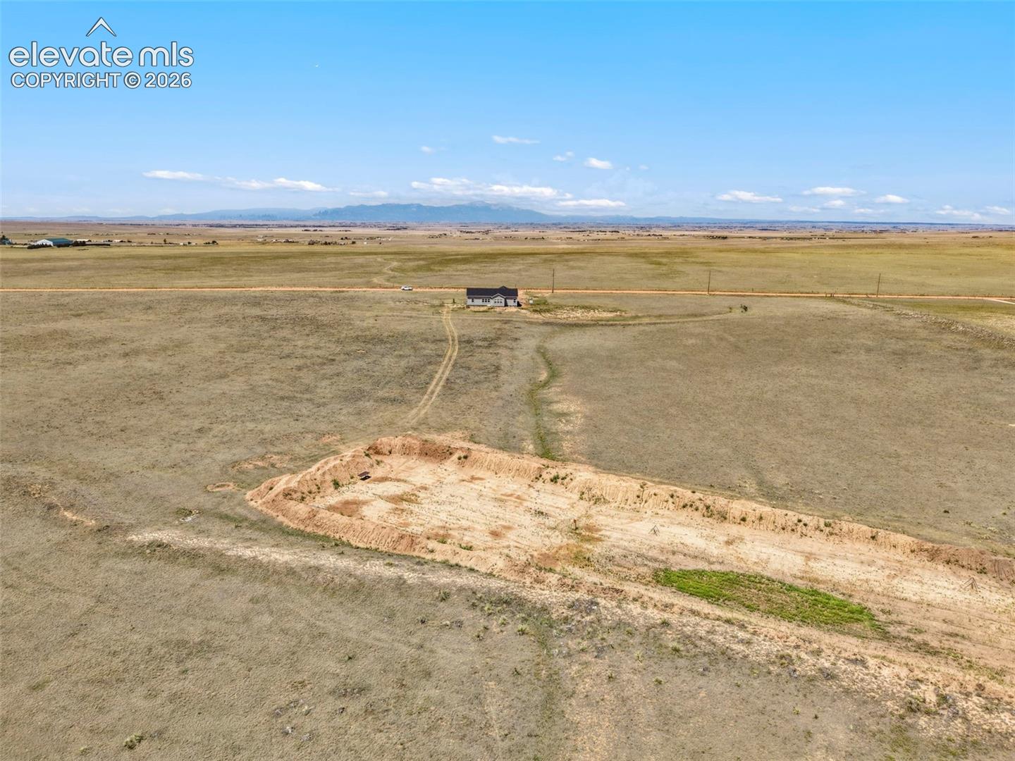 3955 North Yoder Road Yoder, CO 80864 - Photo 36 of 38 Expansive land parcel featuring a distant single-family residence, a cleared building area, and a flat topography