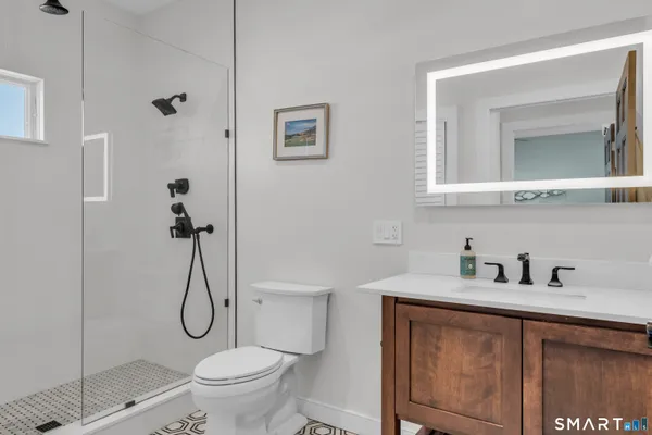a bathroom with a granite countertop sink a toilet and shower