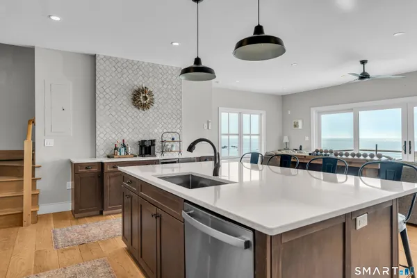 a kitchen with stainless steel appliances granite countertop a sink a stove and refrigerator