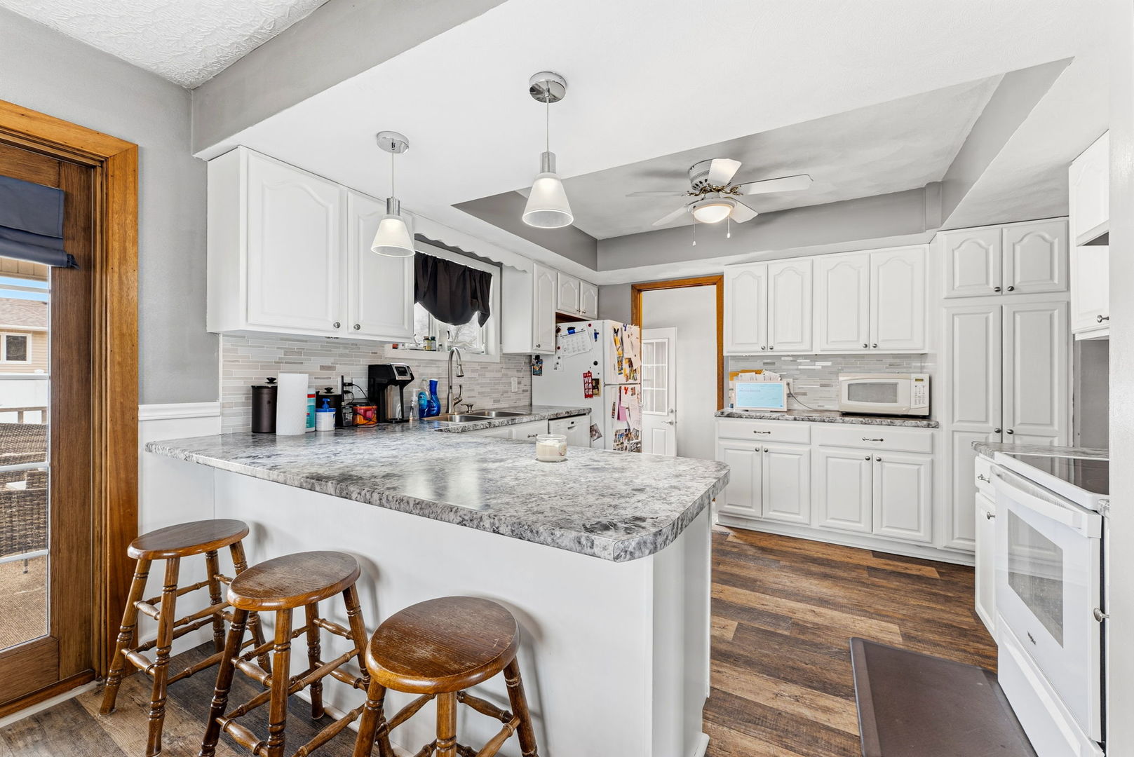 404 Southwest 10th Street Aledo, IL 61231 - Photo 9 of 27 a kitchen with stainless steel appliances granite countertop a sink a stove a refrigerator cabinets and chairs