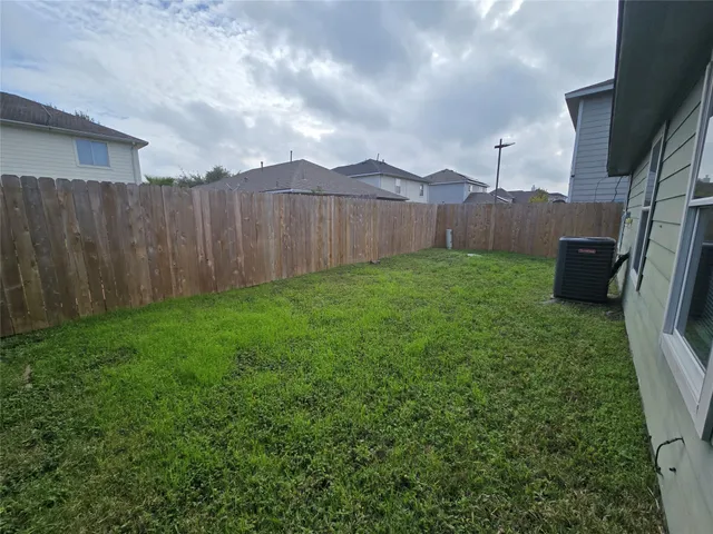 a view of a backyard with wooden fence