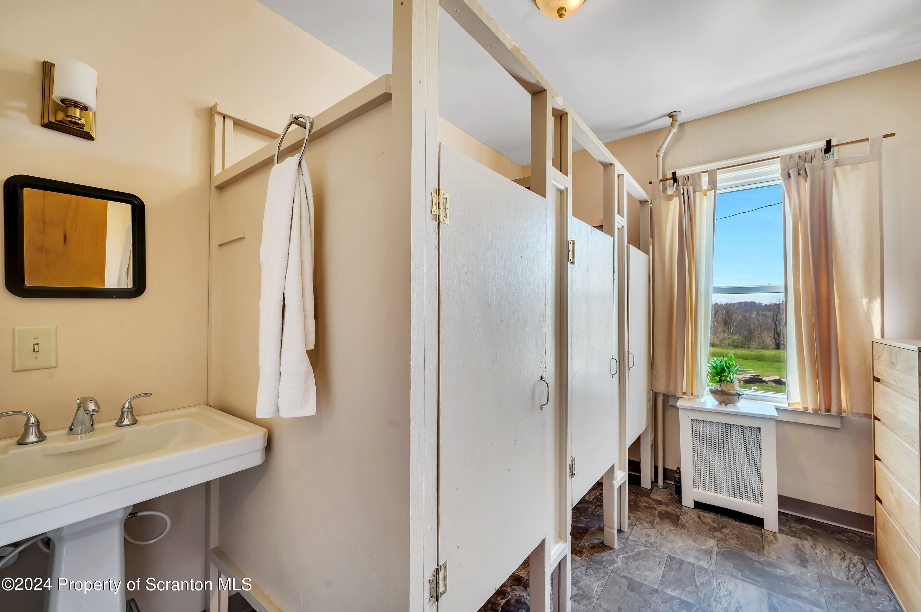 1128 County Home Road Montrose, PA 18801 - Photo 35 of 68 a bathroom with a granite countertop sink a mirror a shower and a window