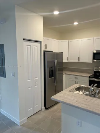 a kitchen with stainless steel appliances granite countertop a refrigerator and a sink