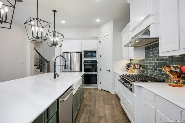 a kitchen with sink a stove and cabinets