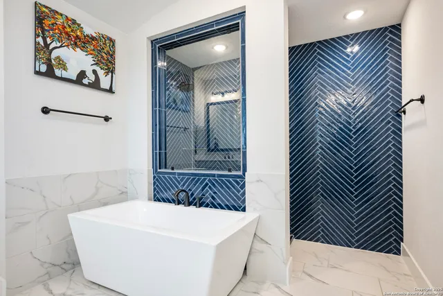 a bathroom with a tub sink and mirror