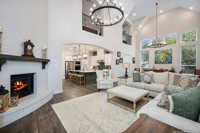 a living room with furniture a fireplace and a floor to ceiling window