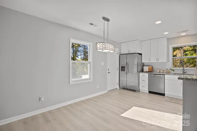 a kitchen with stainless steel appliances a refrigerator sink and cabinets
