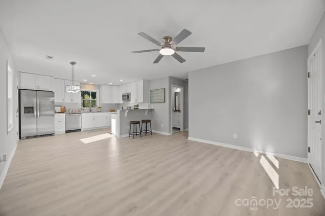 a view of a kitchen with wooden floor and a window