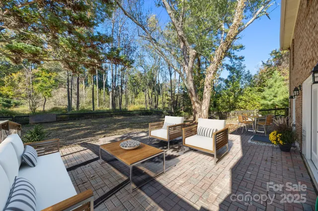 a view of a patio with couches and a table and chairs with wooden floor and fence