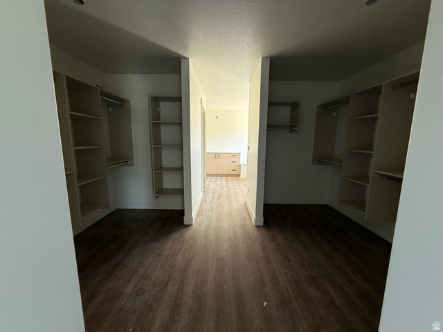 3308 South 1000 West Logan, UT 84321 - Photo 7 of 14 Spacious walk-in closet featuring wood-finish flooring, built-in shelving, and hanging rods