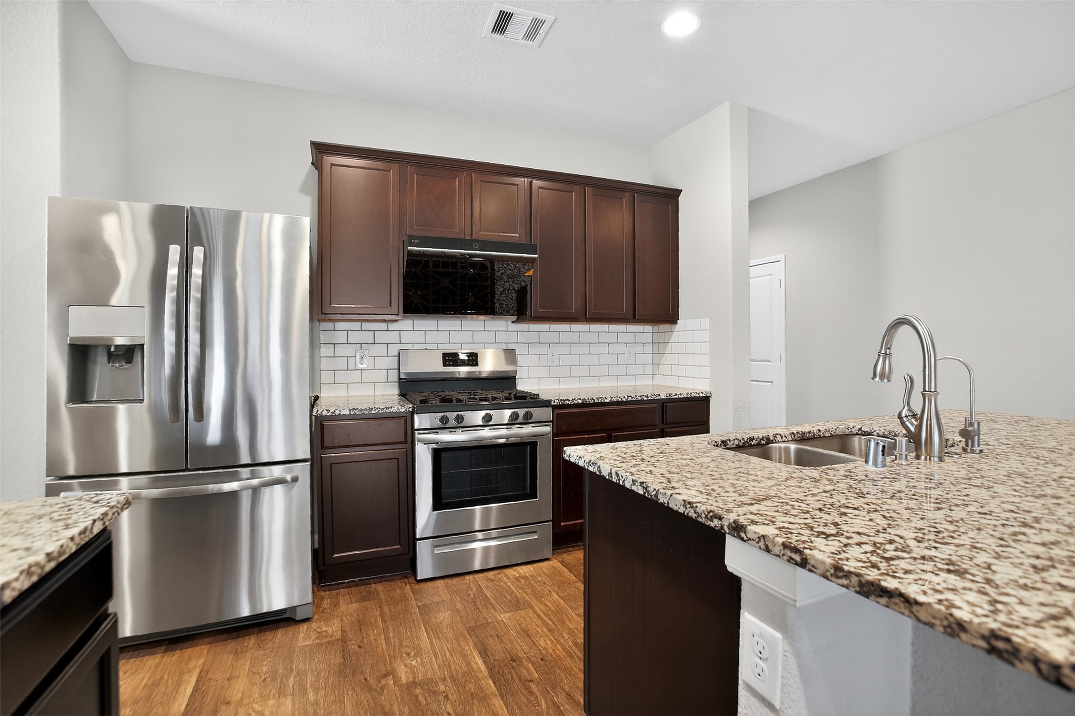 3310 Sumac Drive Katy, TX 77494 - Photo 6 of 45 a kitchen with granite countertop a refrigerator stove and kitchen island