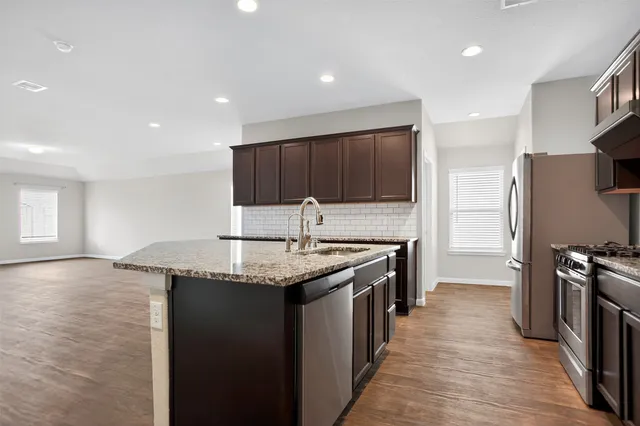 a kitchen with stainless steel appliances granite countertop a sink stove and refrigerator