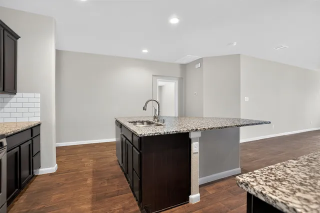 a kitchen with granite countertop a sink and a stove