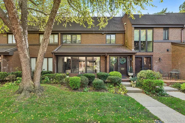 front view of a brick house with a yard