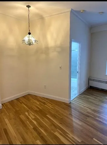 a view of a room with wooden floor and ceiling fan