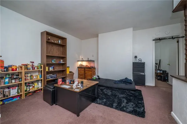 a living room with furniture a rug and a book shelf