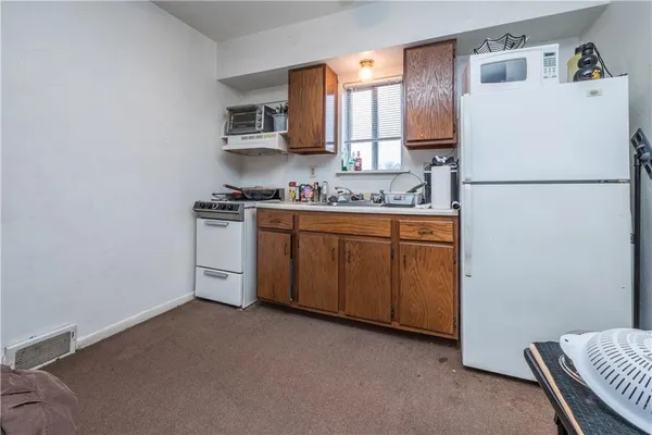 a kitchen with stainless steel appliances granite countertop a refrigerator a stove a sink and a microwave