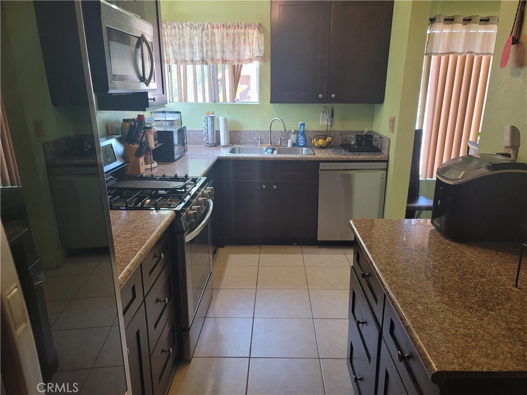 1408 South Burris Avenue Compton, CA 90221 - Photo 13 of 29 a kitchen with stainless steel appliances granite countertop a sink stove and cabinets