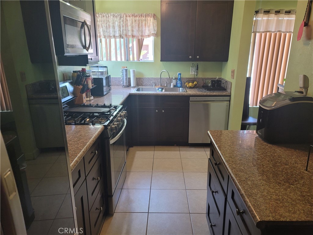 1408 South Burris Avenue Compton, CA 90221 - Photo 14 of 29 a kitchen with stainless steel appliances granite countertop a sink stove and cabinets