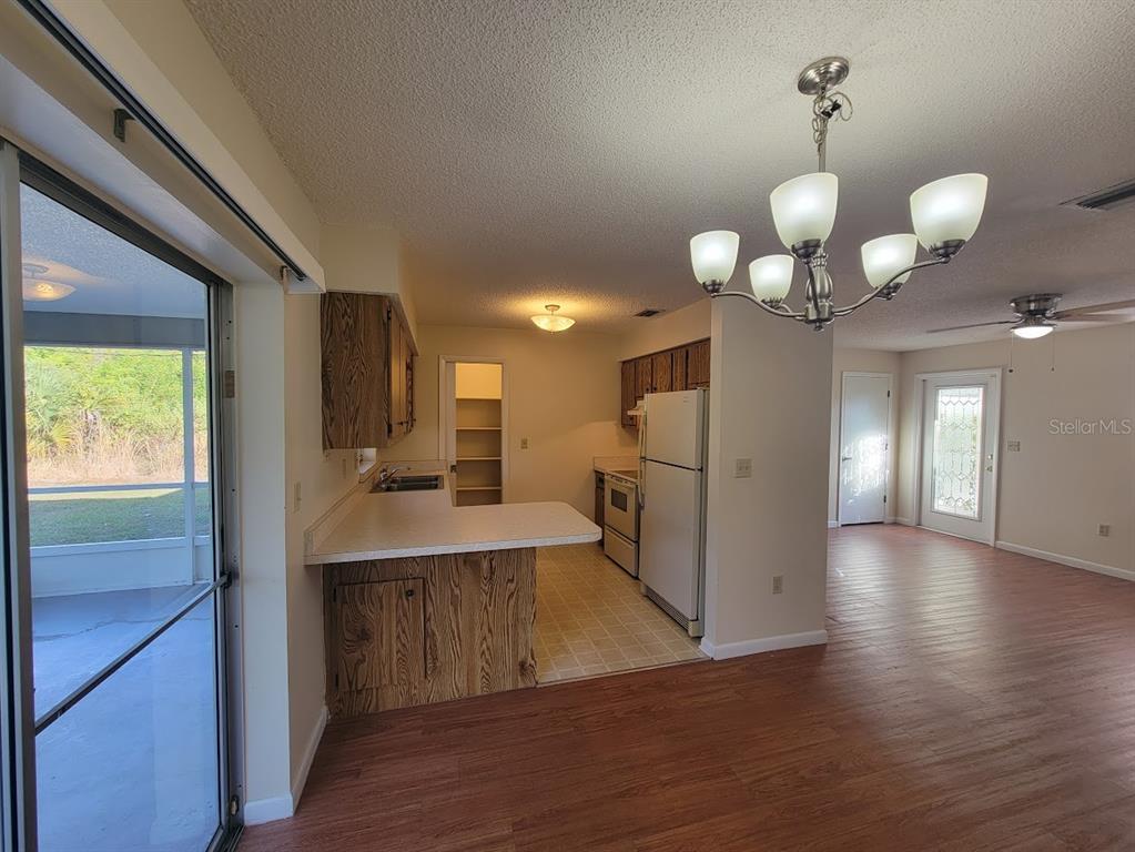 23358 Racine Avenue Punta Gorda, FL 33980 - Photo 2 of 28 a view of a kitchen center island wooden floor and living room view