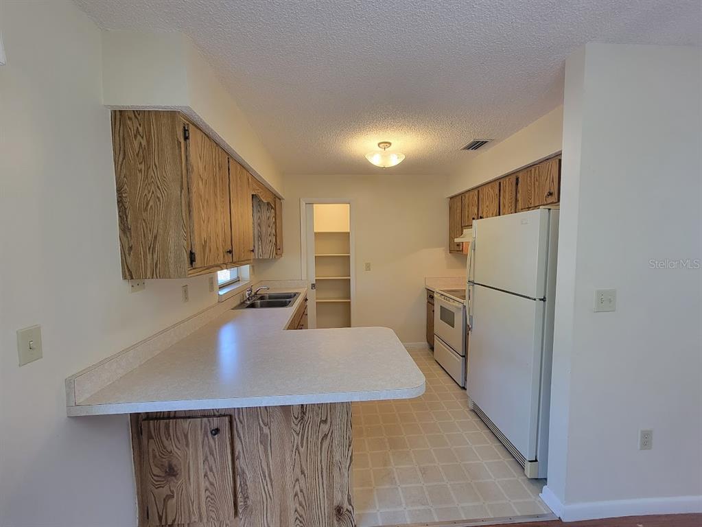 23358 Racine Avenue Punta Gorda, FL 33980 - Photo 6 of 28 a kitchen with refrigerator and cabinets