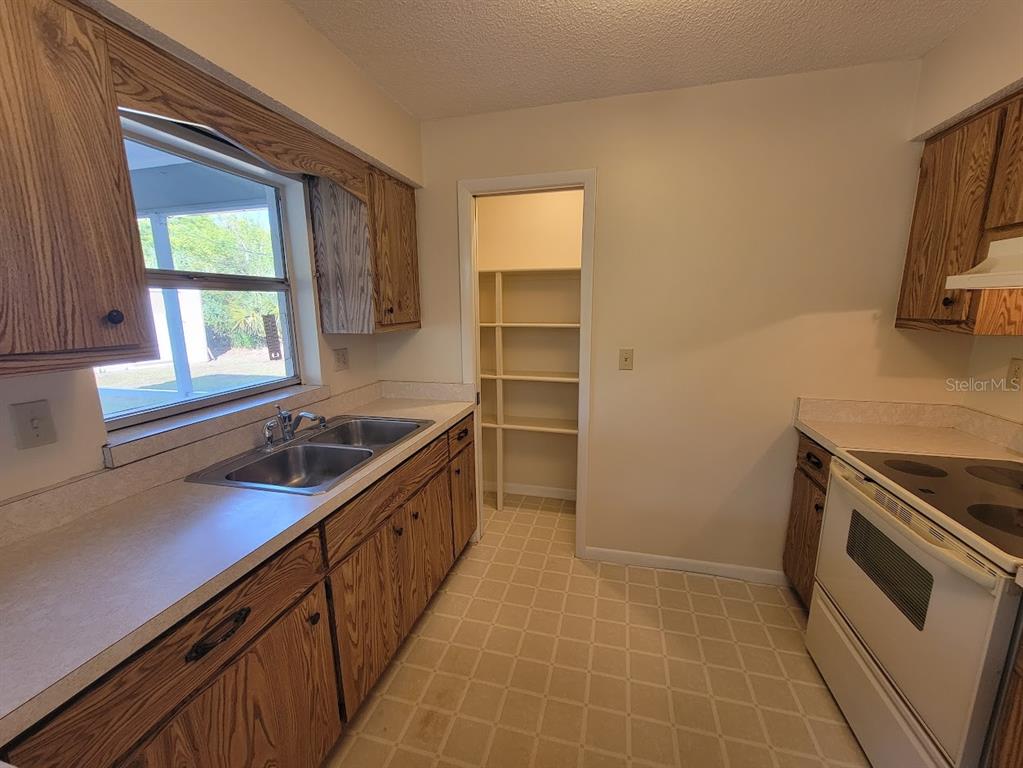 23358 Racine Avenue Punta Gorda, FL 33980 - Photo 7 of 28 a kitchen with a sink stove and cabinets