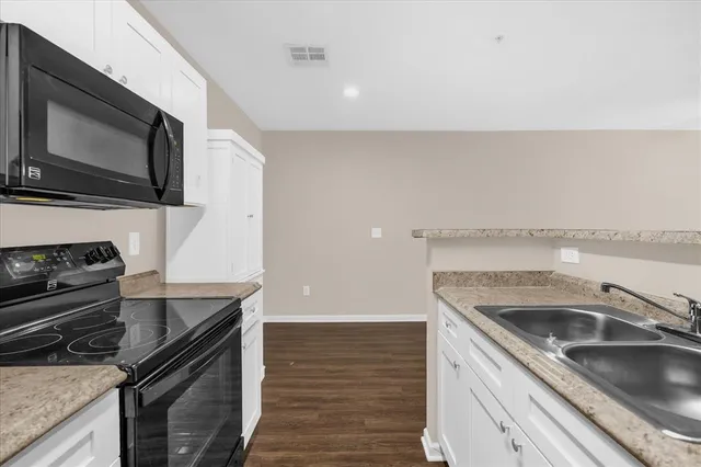 a kitchen with a sink stove and microwave