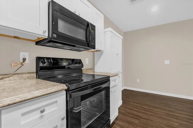 a kitchen with wooden floor and a stove top oven