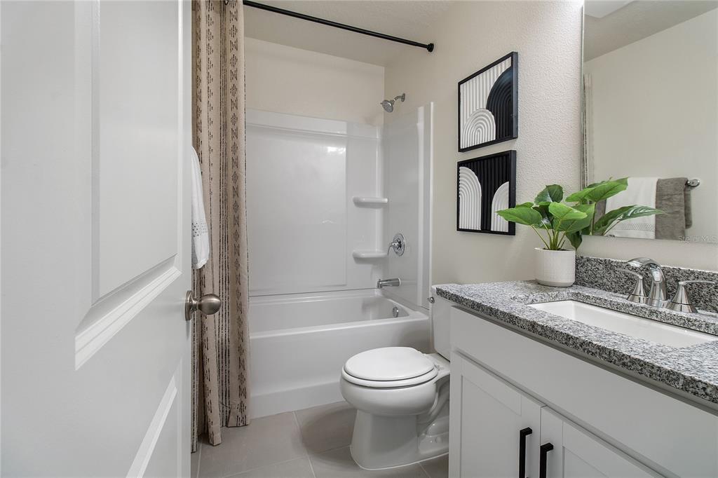 16639 Luminary Loop Clermont, FL 34714 - Photo 14 of 26 a bathroom with a granite countertop sink toilet and shower