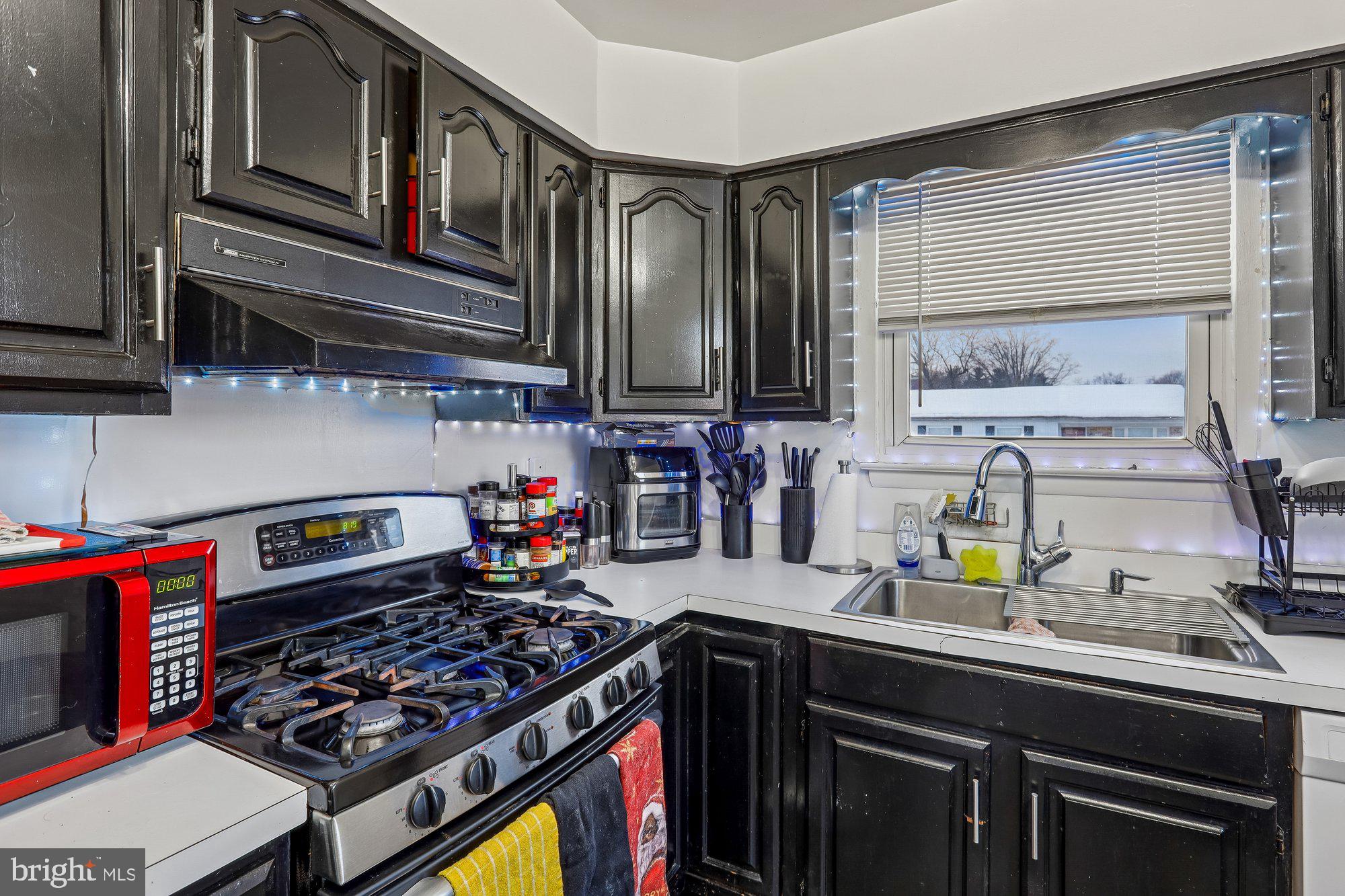 3723 Eastman Road Randallstown, MD 21133 - Photo 11 of 36 a kitchen with lots of stainless steel appliances a stove and a sink