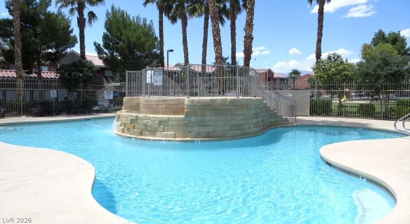 4730 East Craig Road, Unit 1154 Las Vegas, NV 89115 - Photo 1 of 13 A refreshing pool awaits, complete with a rock waterfall feature and surrounding palm trees.