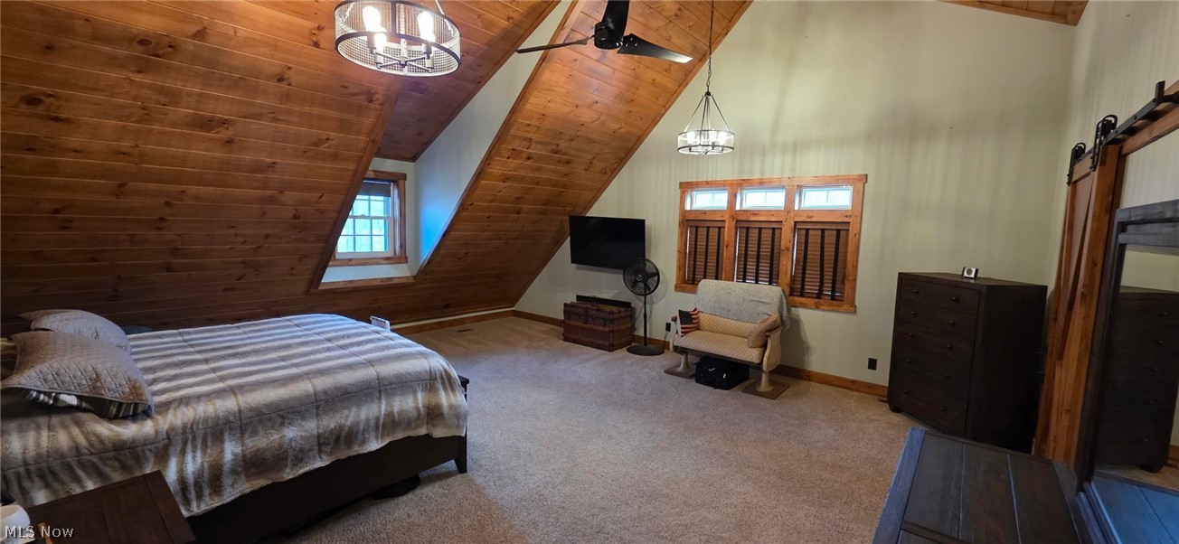 3989 Court Road Wakeman, OH 44889 - Photo 14 of 36 Carpeted bedroom featuring a barn door leading to huge walk-in closet, a vaulted wood ceiling, and suspended lighting