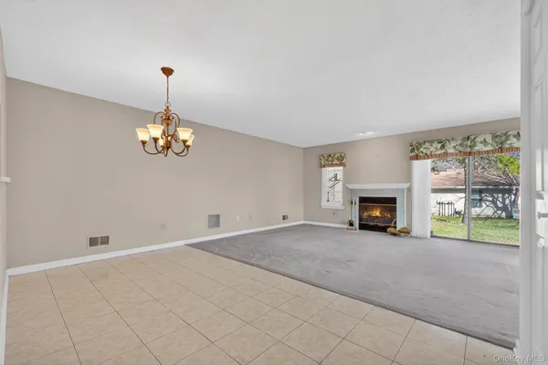 a view of an empty room with a window and fireplace