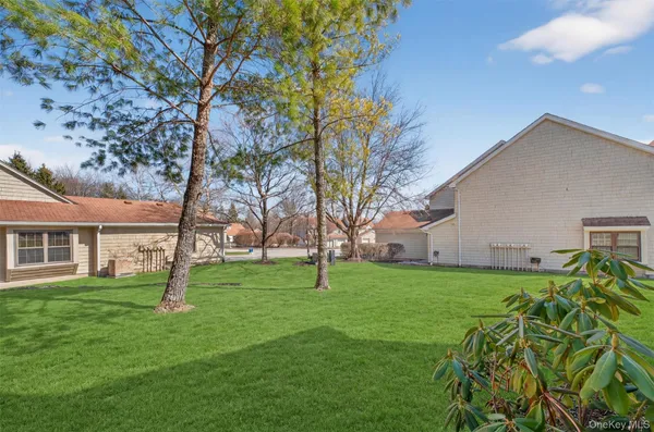 a view of a backyard with table and chairs and a large tree