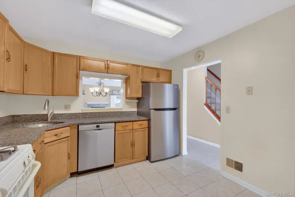 a kitchen with stainless steel appliances granite countertop a refrigerator and a sink