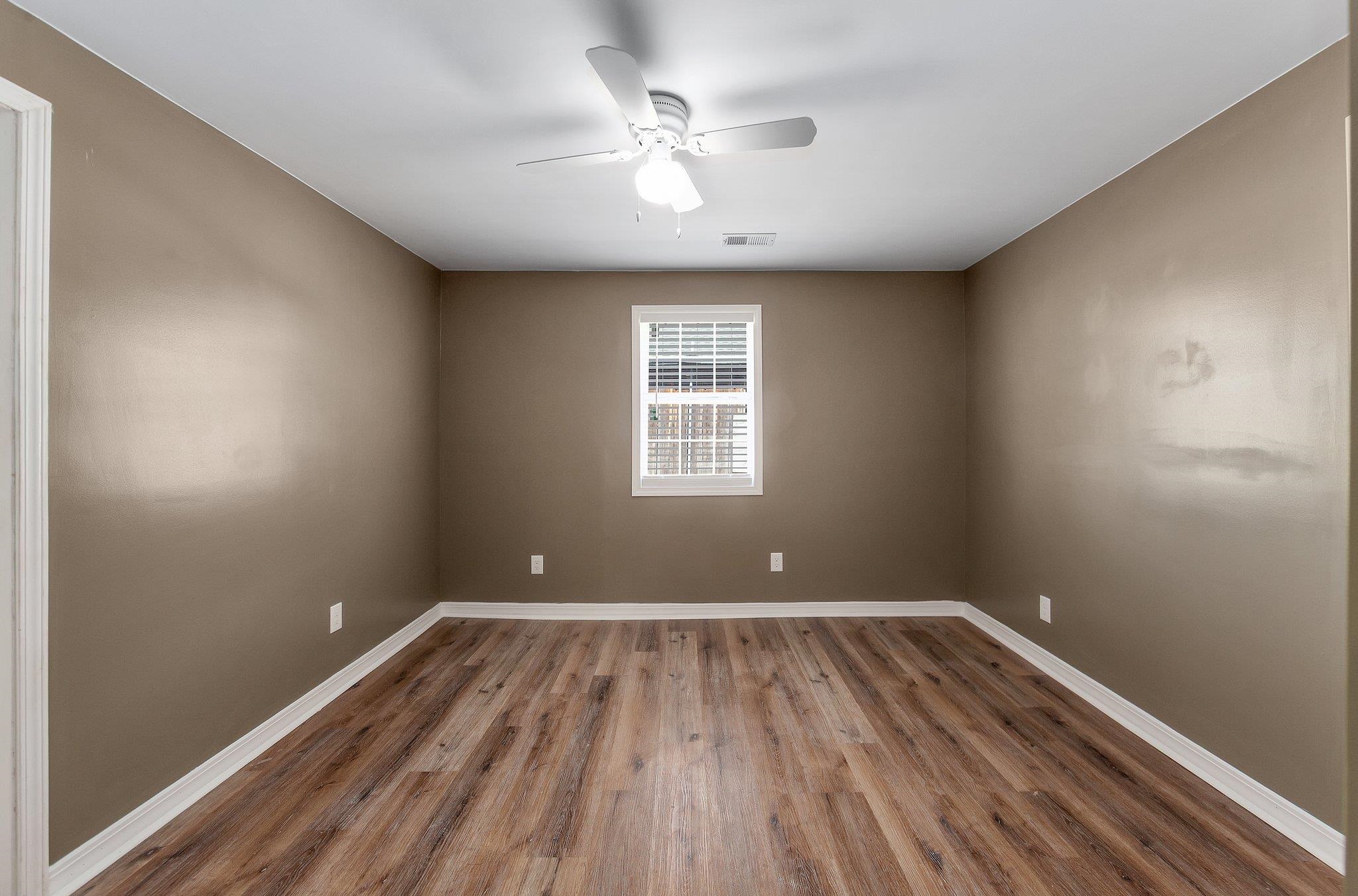 115 Carson Street Jackson, TN 38301 - Photo 12 of 14 wooden floor in an empty room with a window