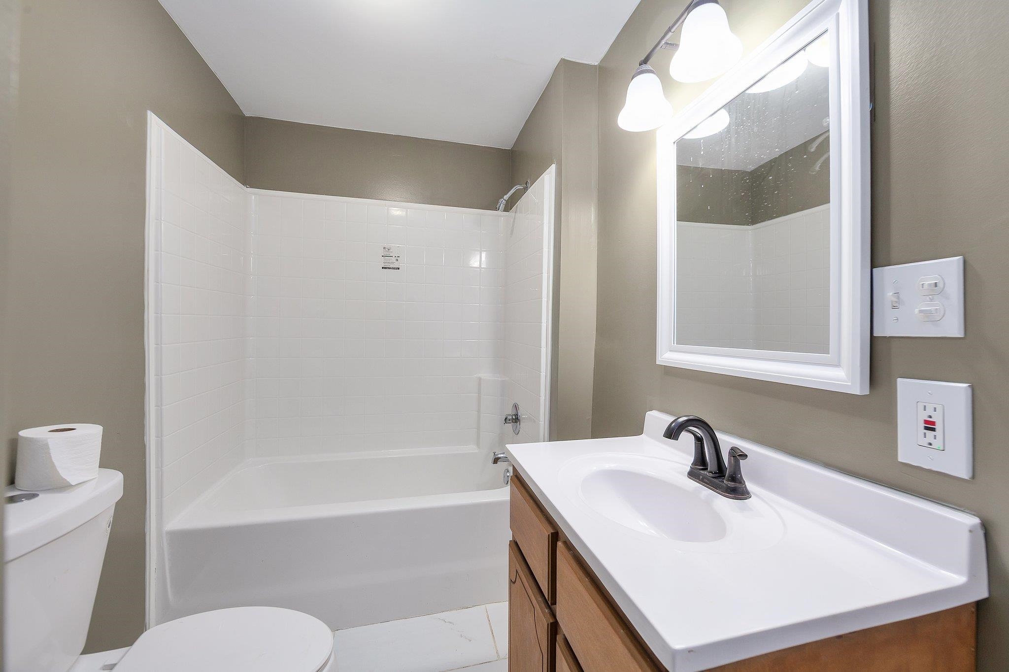 115 Carson Street Jackson, TN 38301 - Photo 7 of 14 a bathroom with a sink a toilet and a mirror