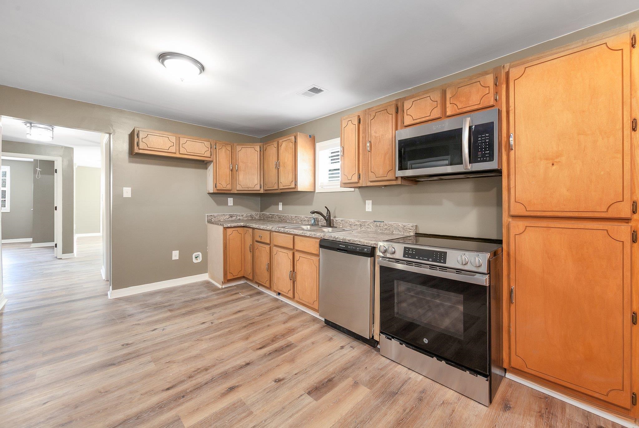 115 Carson Street Jackson, TN 38301 - Photo 10 of 14 a kitchen with stainless steel appliances granite countertop a stove a sink and a microwave
