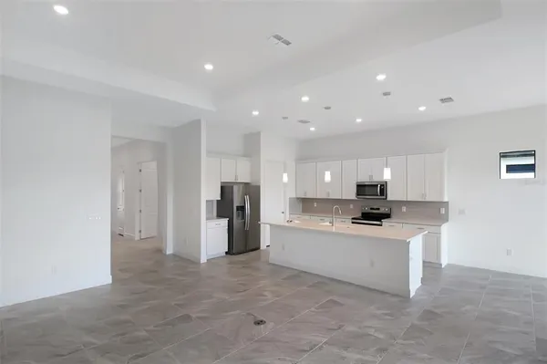 a kitchen with white cabinets and black appliances