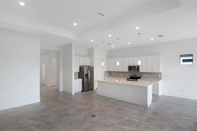a kitchen with white cabinets and black appliances